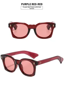 Détail de lunettes de soleil en résine rouge violacé avec rivets dorés et verres roses