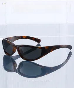 Vue détaillée de lunettes de soleil sport Y2K écaille de tortue avec verres foncés sur surface miroir