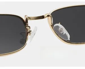 Détail du pont en métal doré et des plaquettes en silicone transparent des lunettes