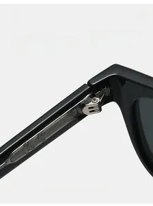 Détail de la charnière en métal robuste sur lunettes de soleil en acétate noir avec marquage CE