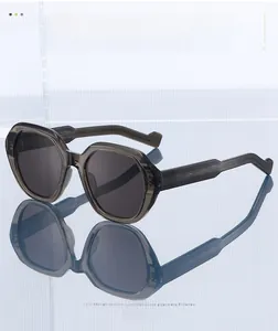 Close-up of polygon sunglasses with wave-textured temples on a blue reflective surface