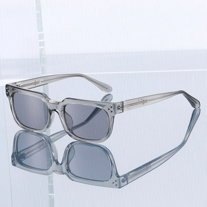 Lunettes de soleil carrées gris transparent avec verres polarisés sur surface miroir