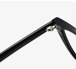 Macro shot of black cat-eye eyeglass frame hinge and inner temple with size markings