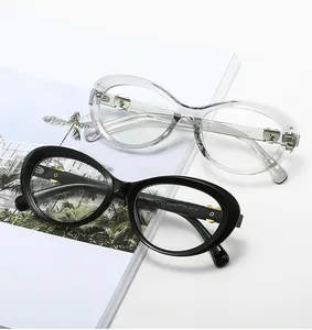 Detailed view of cat-eye glasses frames with gold heart accents on hinge over a magazine