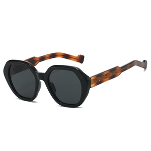 Geometric black sunglasses with tortoiseshell wavy temples on a white background