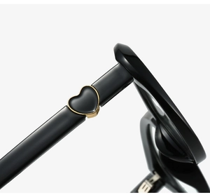 Detail view of glossy black glasses temples with elegant gold-edged heart decoration
