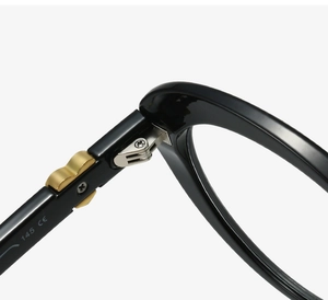 Detail of the silver metal hinge and gold wavy trim on black cat-eye glasses frames