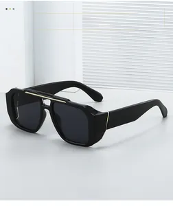 Détail de lunettes de soleil noires avec pont doré et verres gris fumé foncés
