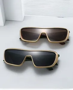 Close-up of retro oversized rectangular sun shields with golden metal frames and gradient lenses