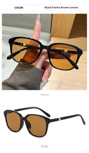 Detail einer quadratischen schwarzen Sonnenbrille mit braunen Gläsern und Perlenverzierung