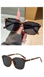 Detail der quadratischen Sonnenbrille mit Leopardenmuster, grauen Gläsern und Scharnier