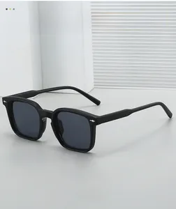 Detailed close-up of matte black square sunglasses with silver arrow rivet accents