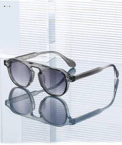 Gros plan de lunettes de soleil grises avec rivets argentés et verres dégradés