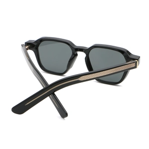 Detail of black geometric sunglasses with golden grid texture on the temple