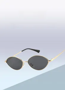 Detail view of oval metal sunglasses with golden frame and dark lenses on gradient background
