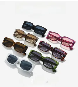 Flat lay of retro square sunglasses in multiple colors like black, white, and tortoise shell