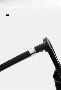 Detail of black glossy temple with silver heart-shaped metal inlay on lightweight glasses