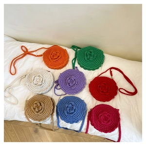 Flat lay of colorful handmade crochet crossbody bags with decorative 3D floral accents