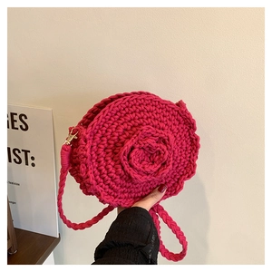 Detail of rose red handmade woven round shoulder bag with 3D floral crochet design