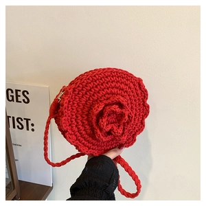 Detail of red handmade crochet rose bag with thick braided strap and top metal zipper