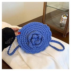 Detailed close-up of blue crochet round bag with handmade 3D rose and gold metal clasp
