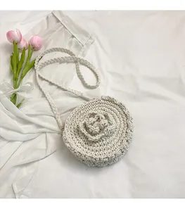 Close-up of handmade off-white crochet shoulder bag featuring 3D floral accents