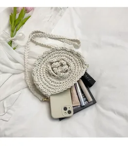 Detail of hand-woven off-white crossbody bag featuring a 3D crochet rose and inner storage