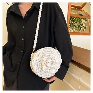 Detail of white handmade crochet crossbody bag featuring a 3D floral rose and braided strap