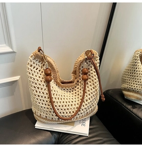 Détail du sac fourre-tout tissé avec anses en cuir marron et perles en bois