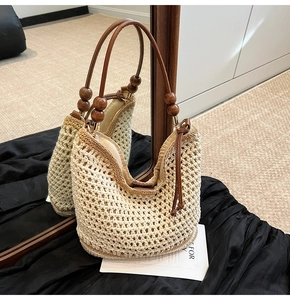 Détail du sac cabas tissé avec poignée en perles de bois et texture bohème