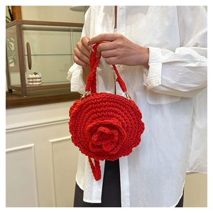 Detail of red handmade woven rose handbag with 3D cotton rope texture for beach vacations