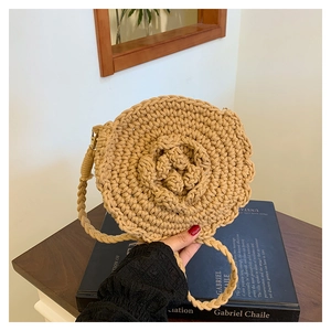 Detail of handmade woven straw bag featuring a 3D crochet flower and fine weave texture