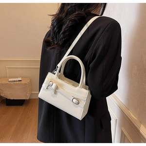 Detail of white vintage tote bag with leather bow and metallic buckle worn on shoulder