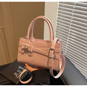 Detailed view of pink PU leather tote with ribbon bow and elegant metal buckle accent