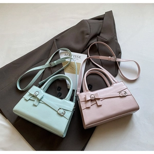Close-up of pastel green and pink handbags with elegant bow and silver buckle details