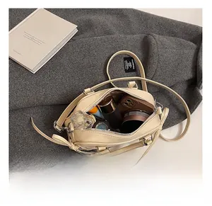 Intérieur spacieux du sac à nœud en cuir crème avec téléphone et cosmétiques