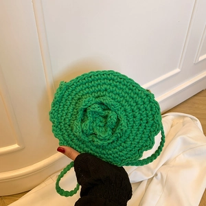 Handmade green woven round crossbody bag featuring 3D floral accent for beach vacations