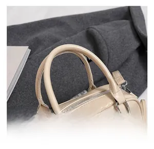 Détail de la poignée en cuir crème et des ferrures métalliques argentées du sac