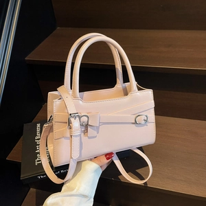 Light pink faux leather handbag with silver buckle bow and adjustable shoulder strap