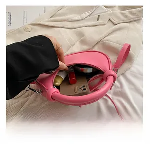 Innenraum der rosa Schultertasche mit Smartphone und Kosmetik für den Alltag