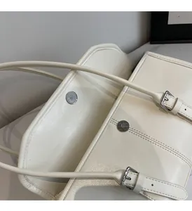 Close-up of cream leather handbag showing interior opening and silver magnetic closure