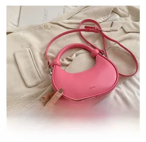 Detailansicht der rosa Halbmondtasche auf beigem Blazer mit elegantem SINVEN-Logo