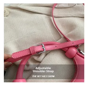 Nahaufnahme des rosa Leder-Schultergurts mit Silberschnalle und Verstelllöchern