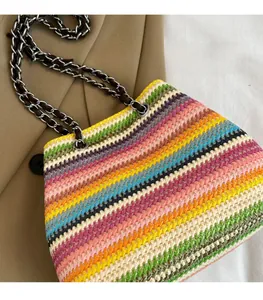 Detail view of woven shoulder bag featuring colorful rainbow stripes and chain strap