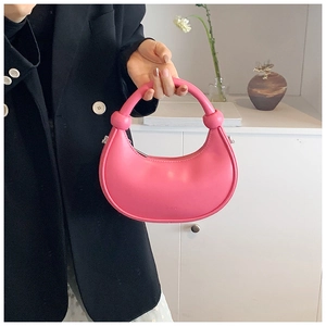 Detail der rosa Hobo-Tasche mit glatter Ledertextur und dekorativem Knotendesign am Griff
