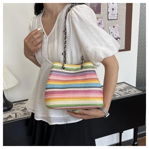 Detail of colorful rainbow woven shoulder bag featuring a silver metal chain strap