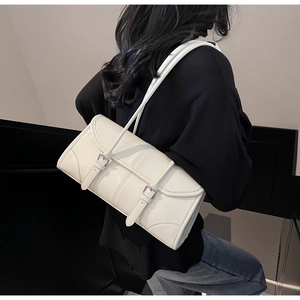 Close-up of minimalist off-white PU leather shoulder bag with decorative silver buckles