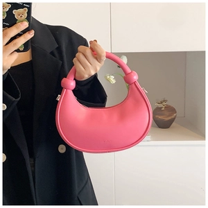 Nahaufnahme der rosa Hobo-Tasche mit geknotetem Griff-Detail in der Hand