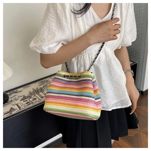 Detailed view of colorful striped woven bucket bag with elegant metal chain strap