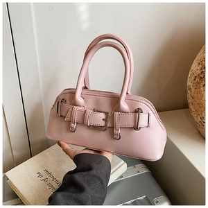 Détail du sac à main rose en similicuir montrant la texture et la sangle à boucle